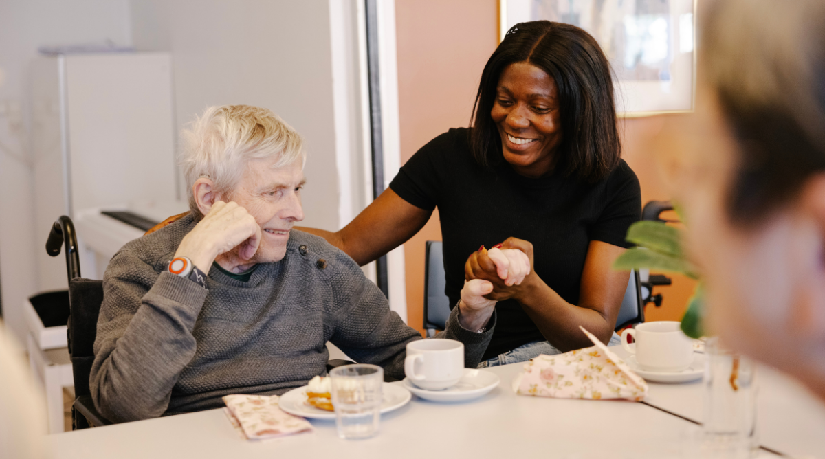 Young woman holding the hand of elderly man – DU at Kærbo Plejecenter 2026